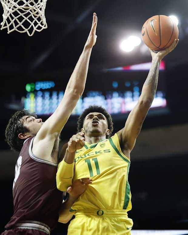Nov 29, 2021; Eugene, Oregon, USA; Oregon Ducks guard Rivaldo Soares (11) shoots the ball as Montana Grizzlies forward Josh Bannan (13, left) defends during the first half at Matthew Knight Arena. Mandatory Credit: Soobum Im-USA TODAY Sports